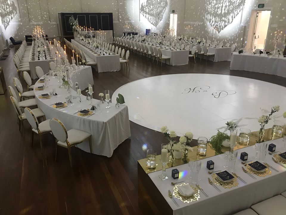 Wedding reception set with a round white dance floor and long tables