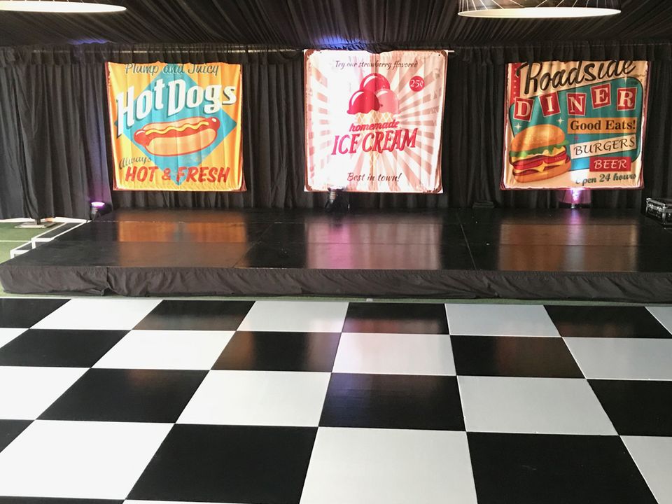 Black and white checkered floor in front of a stage with banners