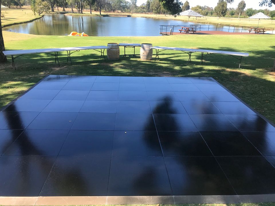 Black gloss dance floor on a lawn reflecting the sky
