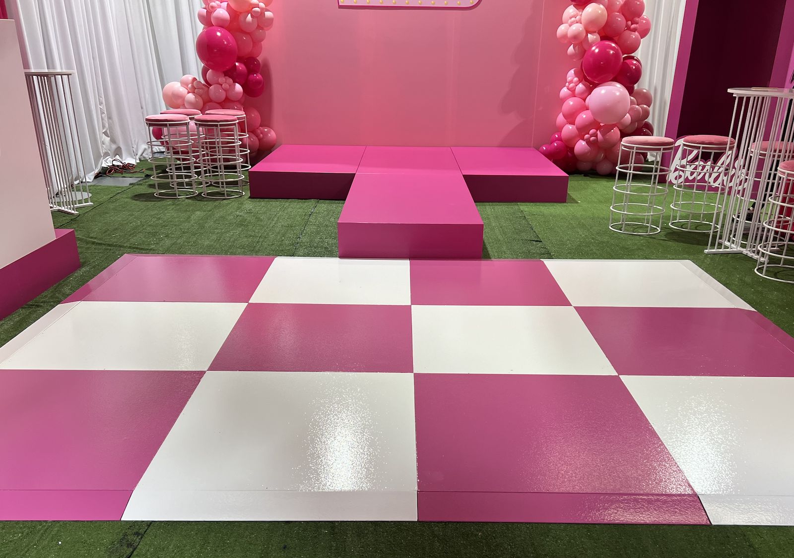 Pink and white checkered dance floor with a pink stage and balloons