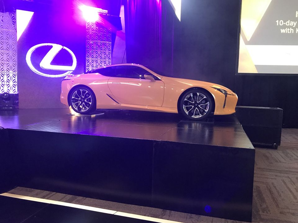 White sports car on a black display plinth at a launch