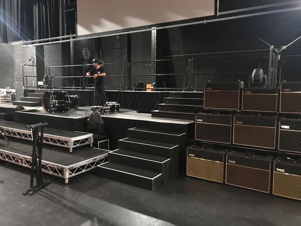 Black tiered stage platforms with steps set up for a band