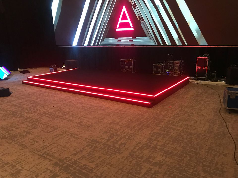 Stage with red LED edge lighting at an evening event