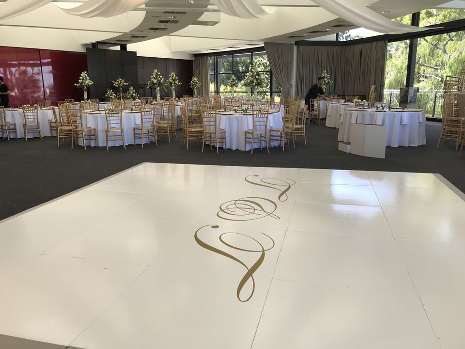 White dance floor with a script monogram at a wedding reception